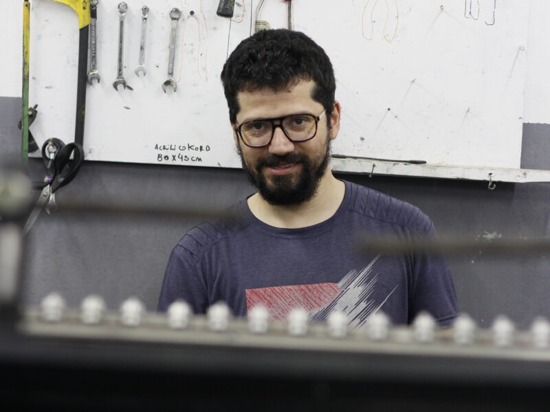 Socio de la cooperativa junto a una de las máquinas del taller
